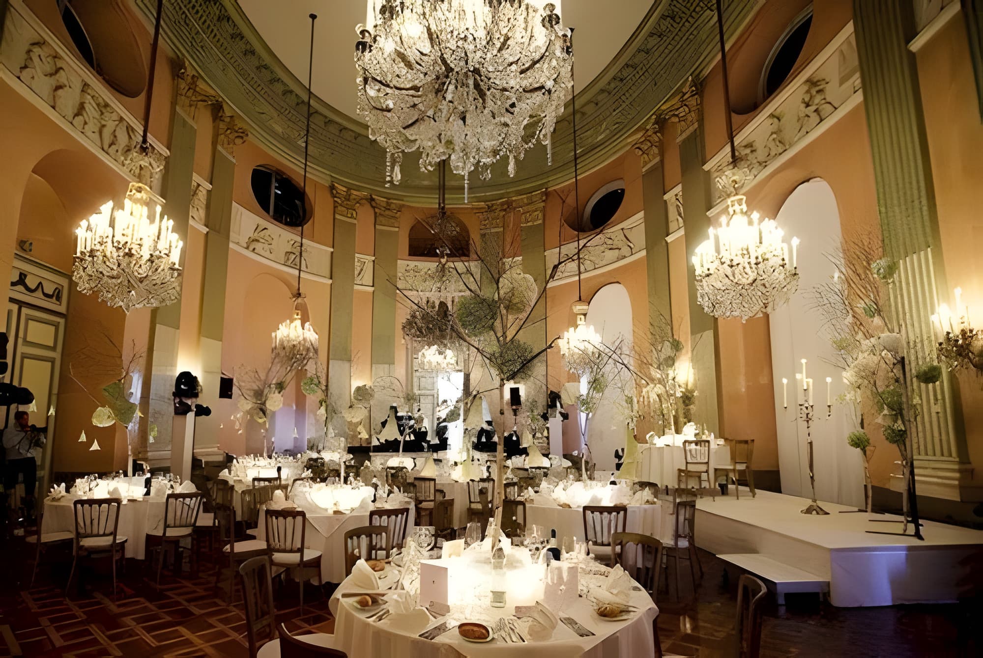 Festive dinner tables beneath crystal chandeliers in the ballroom